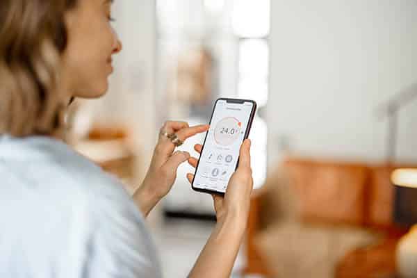 A woman monitors home air quality on her smartphone.